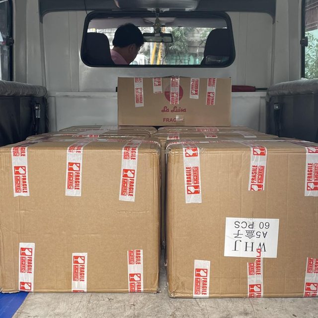 Delivery van loaded with sealed cartons marked fragile, ready to leave the shop.